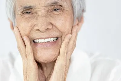 woman loving the look of her smile after getting all-on-4 dental implants at Strawberry Village Dental Care