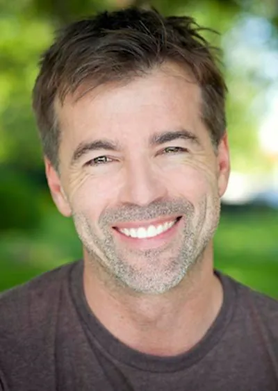 man showing off his restored smile after getting dental crowns