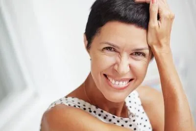 woman showing off her new smile thanks to dentures