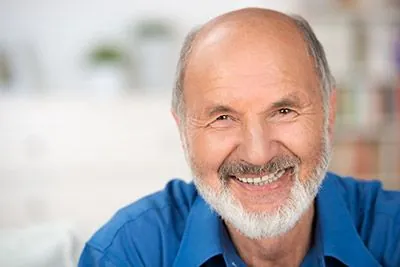 man smiling with his new dentures