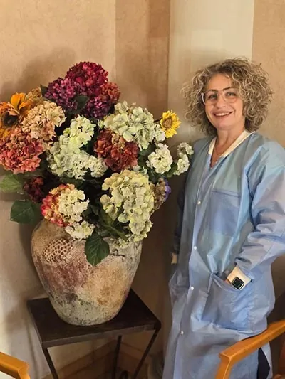 dental assistant posing near vase of flowers